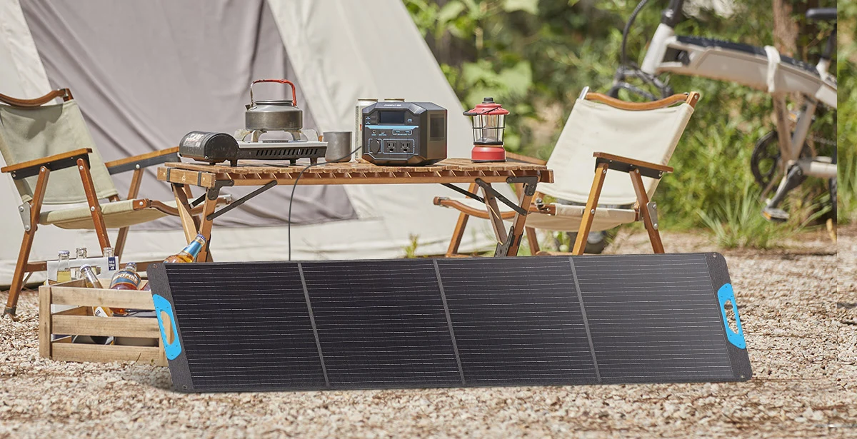 Portable folding solar panel charging a power station at a campsite outdoors