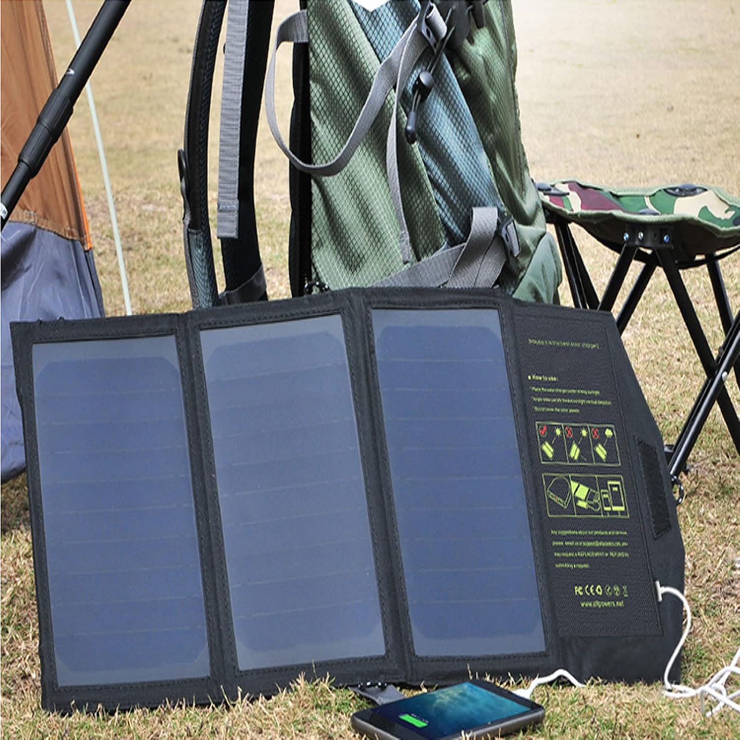 Compact folding solar panel charging a phone during a camping trip