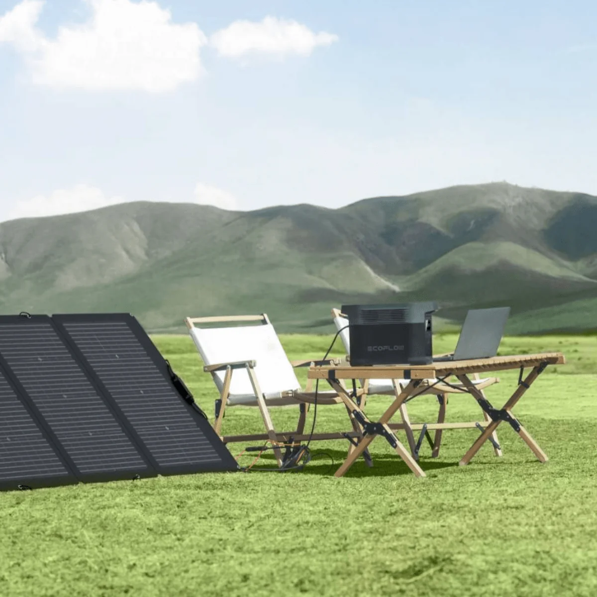 Solar generator with folding panels powering a laptop at an outdoor campsite